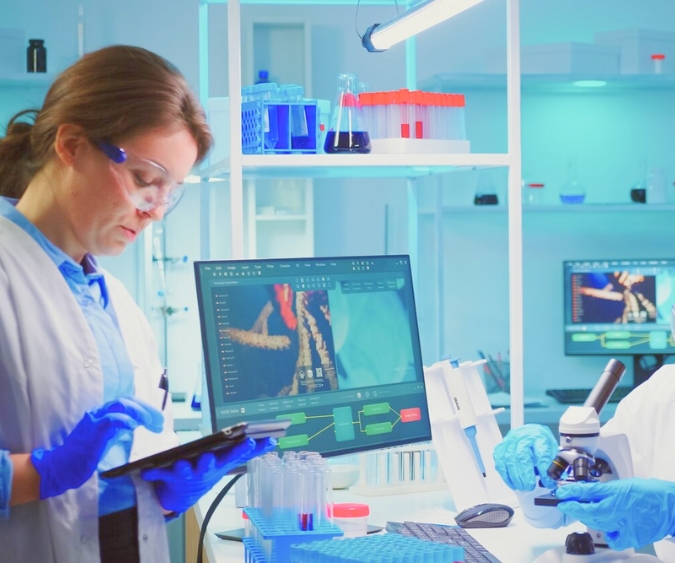 Scientist Standing In Front Of The Microscope